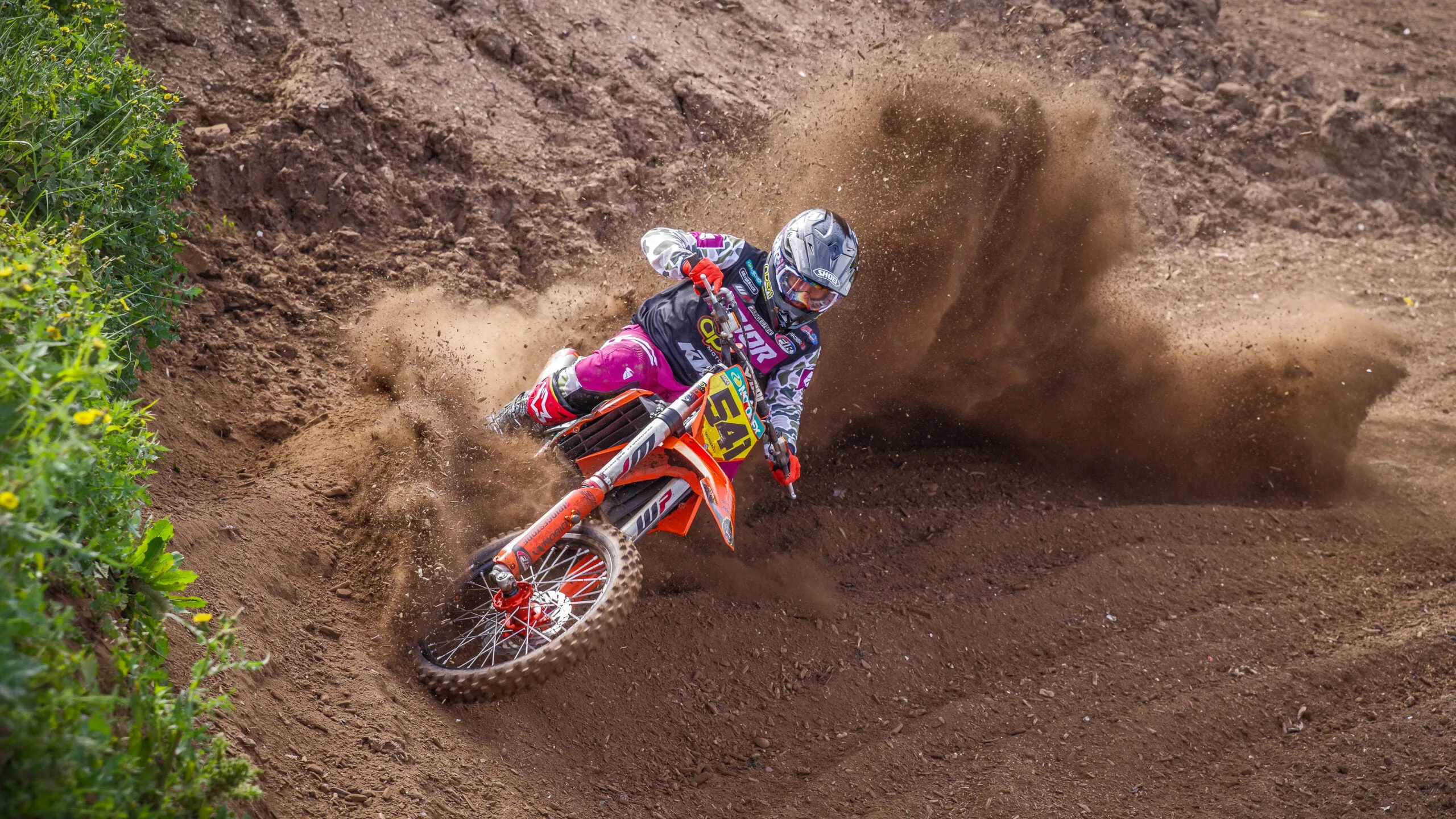 Close-up of riders battling through a berm
